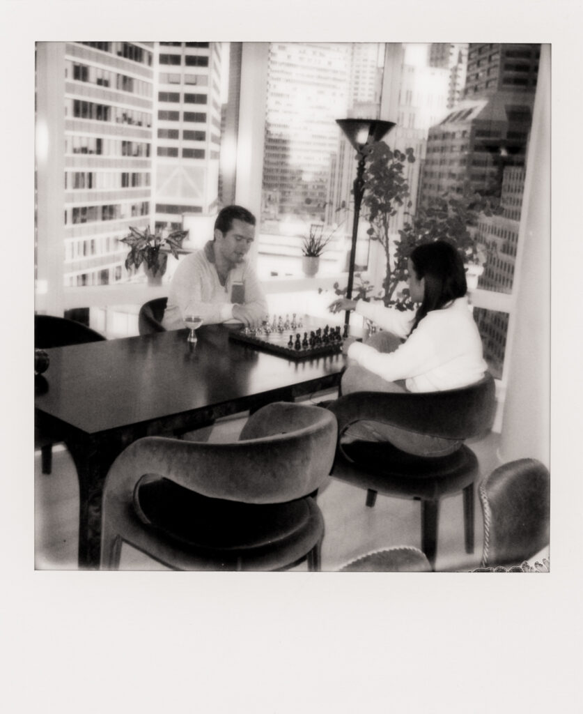 couple playing chess in their apartment during film engagement photos 
