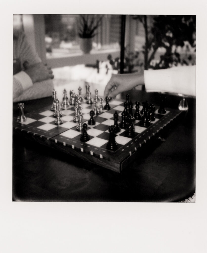 couple playing chess in their apartment during film engagement photos 
