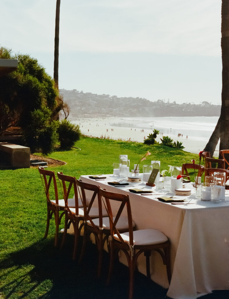 wedding tables, flowers, and string lights on the beach