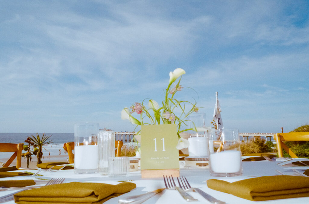 wedding tables and flowers with the sky and ocean in the background 