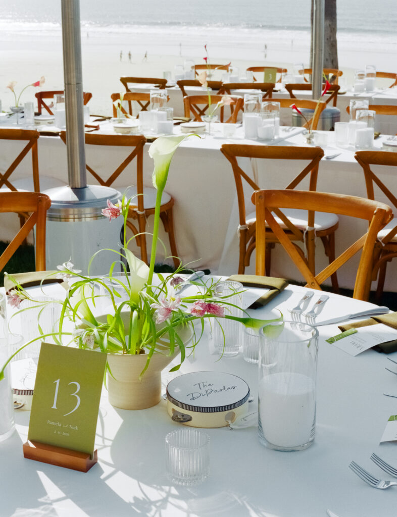 wedding tables, flowers, and string lights on the beach