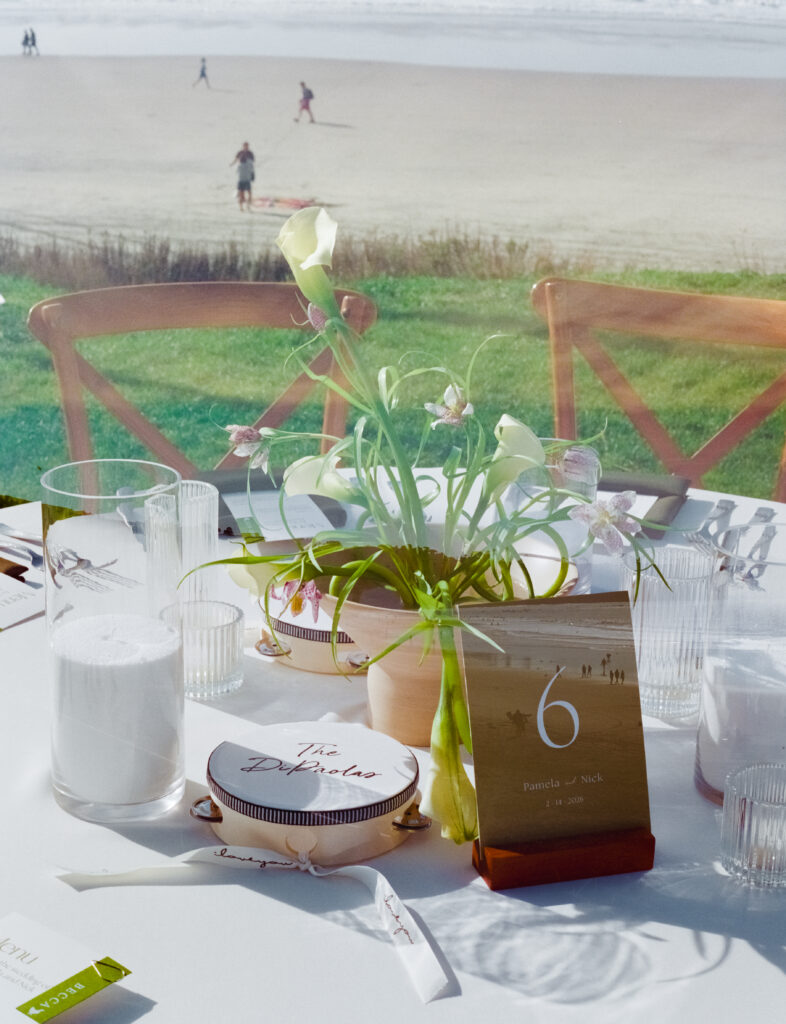 wedding tables and flowers with the beach in the background 