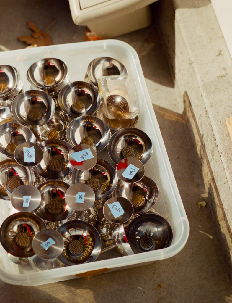 a plastic container with metal floral vases in it