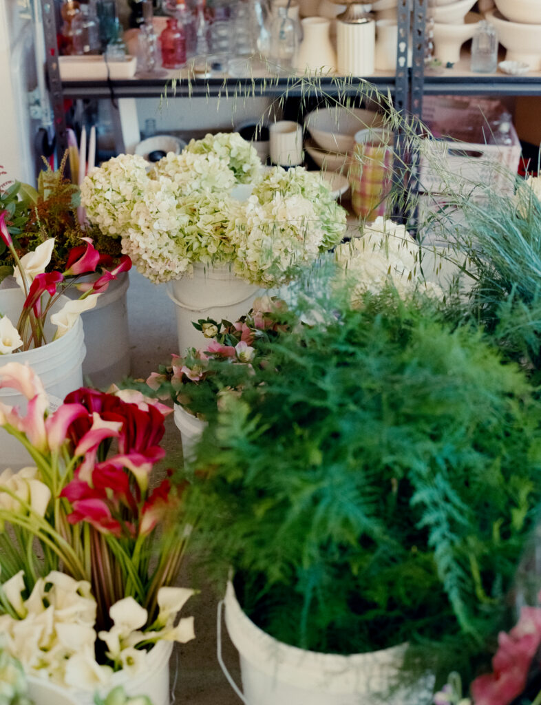 a group of white buckets with flowers