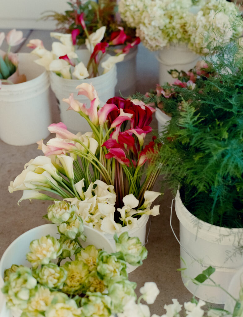 a group of white buckets with flowers