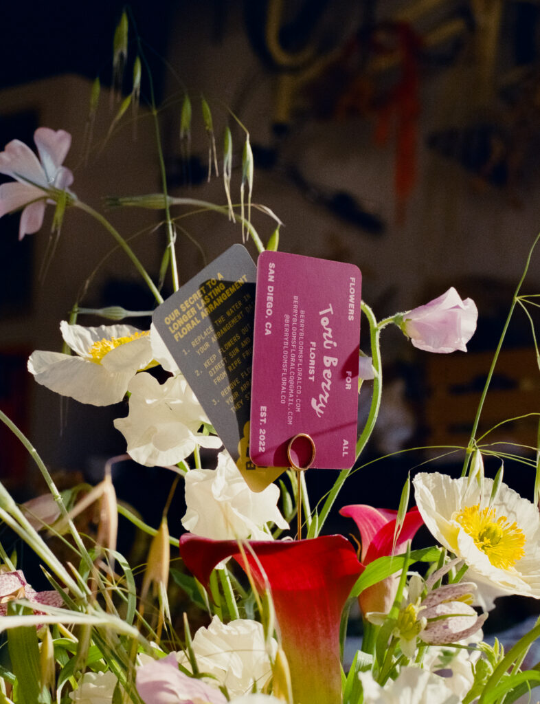 a couple of cards in a vase of flowers