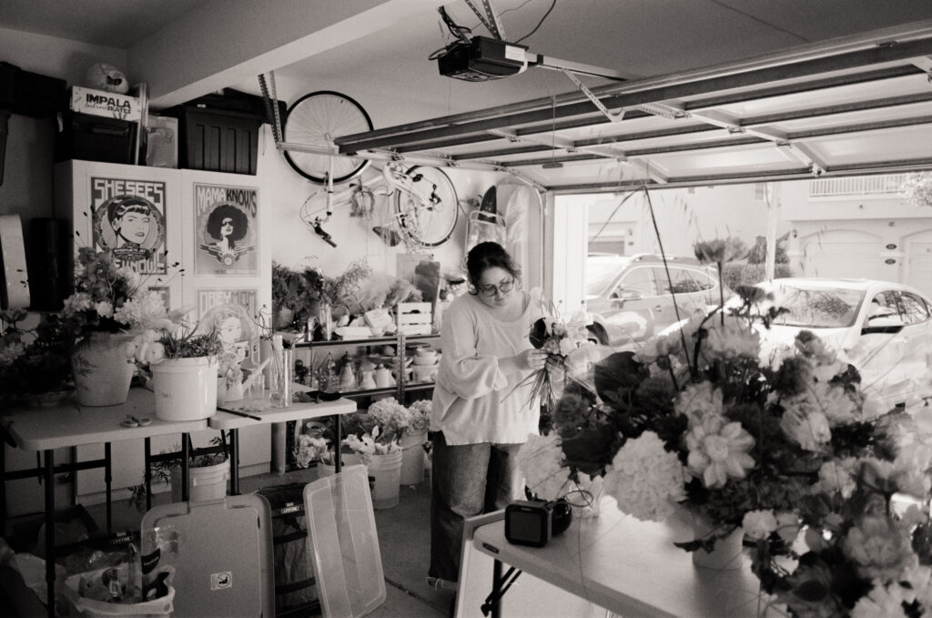 a woman arranging flowers in a garage