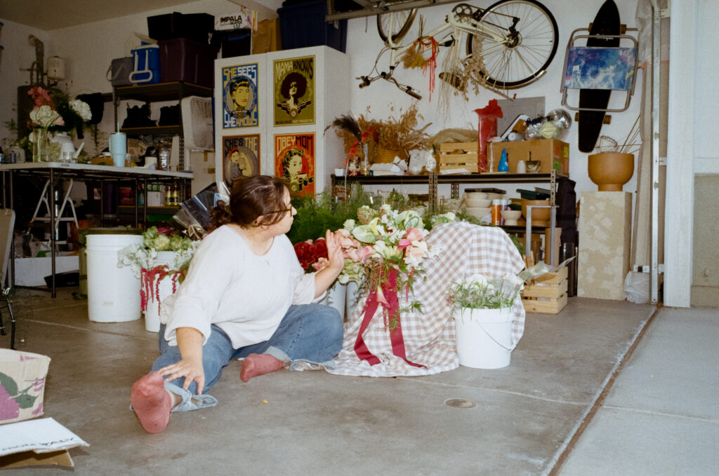 a woman sitting on the floor with a bouquet of flowers