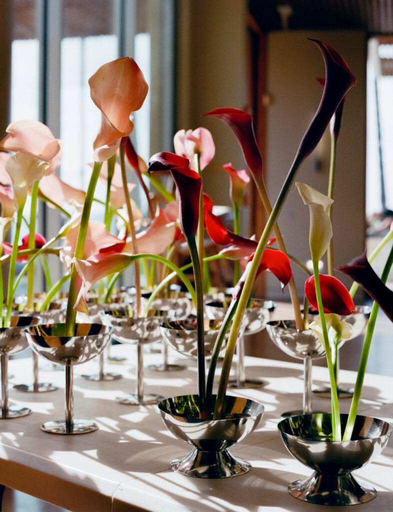 a group of flowers in silver cups
