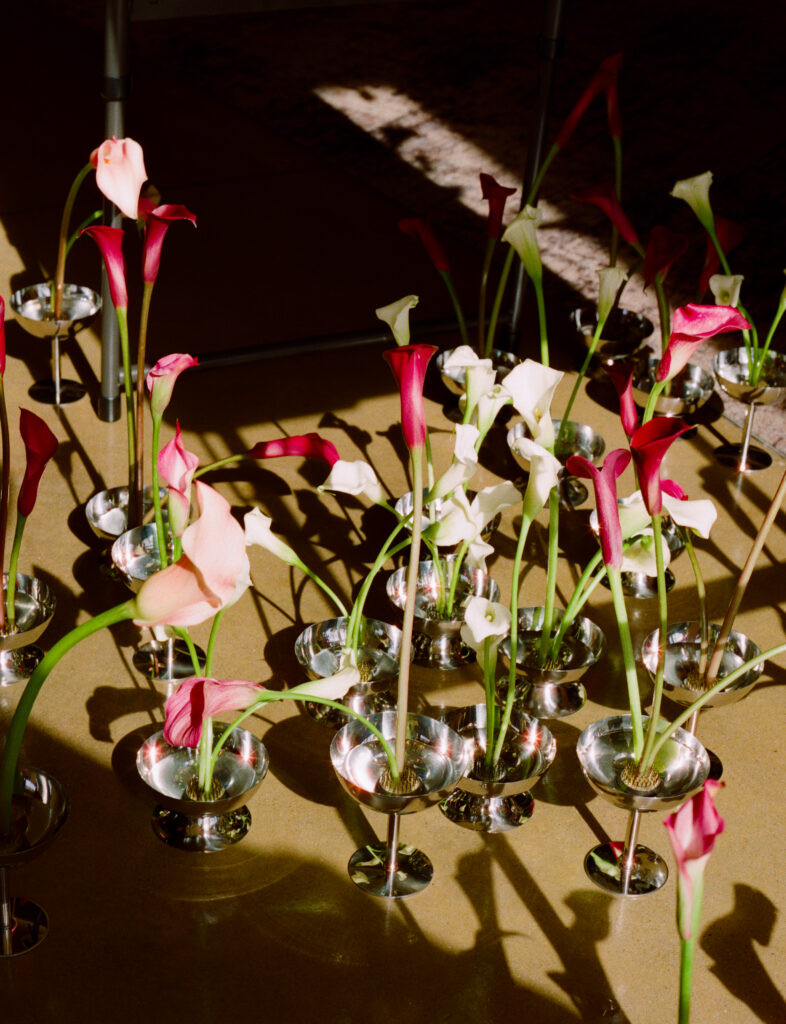 a group of flowers in small glasses