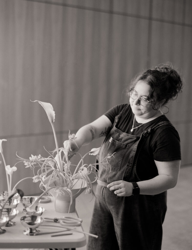 a woman standing next to a plant