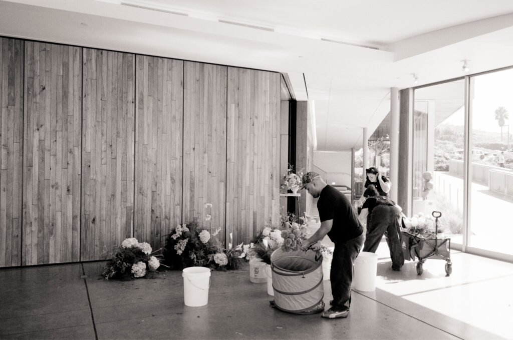 a man and two woman working with flowers in a large room