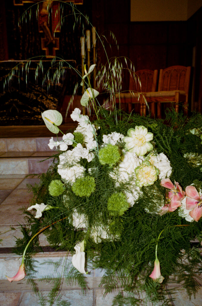 a bunch of flowers and greenery in a room