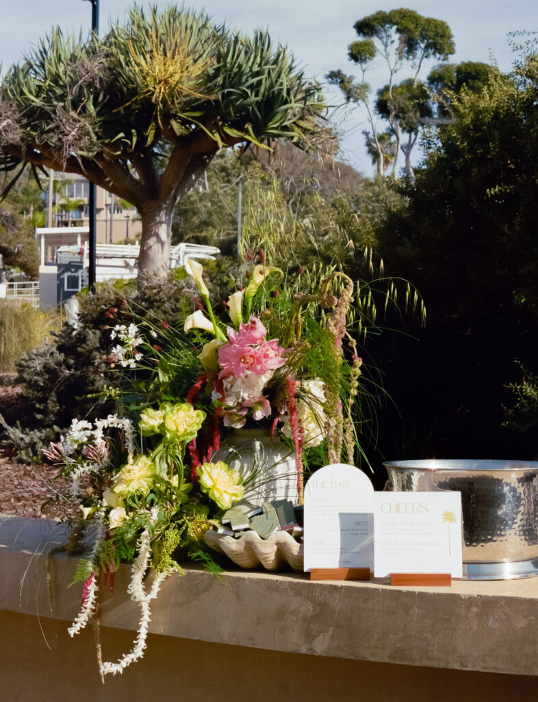 flower arrangement on a table with white signs and ice bucket