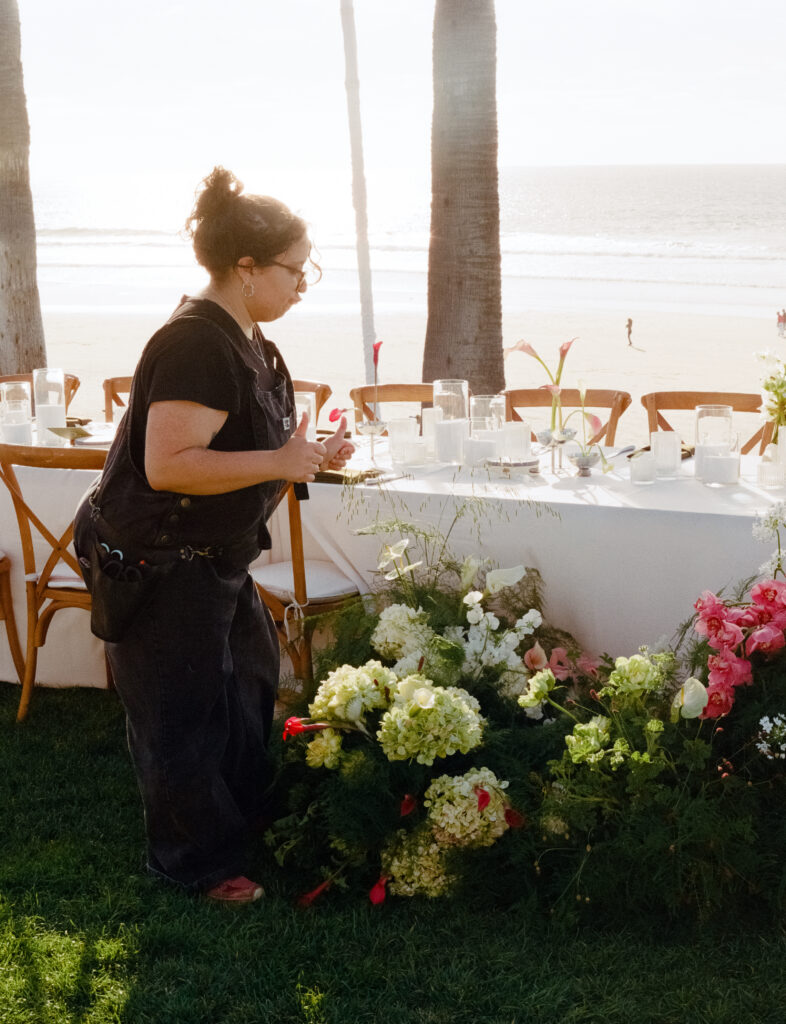 woman working on wedding flower arrangement at the Scripps Seaside Forum In San Diego