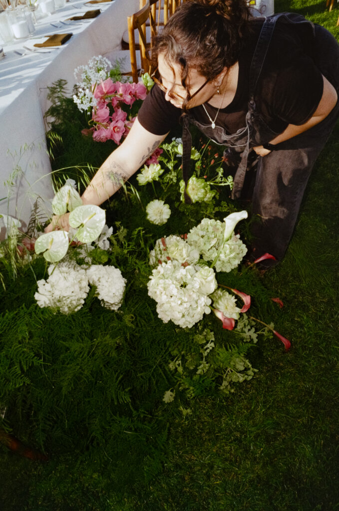 woman working on wedding flower arrangement at the Scripps Seaside Forum In San Diego