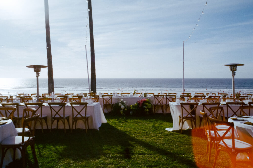 wedding tables, flowers, and string lights on the beach