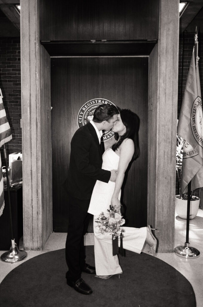 couple kissing at the Boston City Hall after saying their vows during elopement in black and white photo