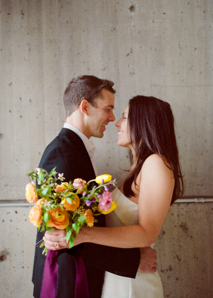 man and woman holding one another and smiling after their Boston City Hall elopement 