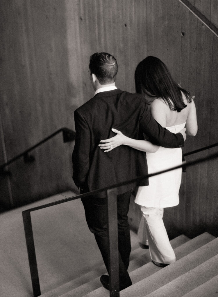 man and woman walking down the stairs with arms around each other after they eloped at the Boston City Hall 