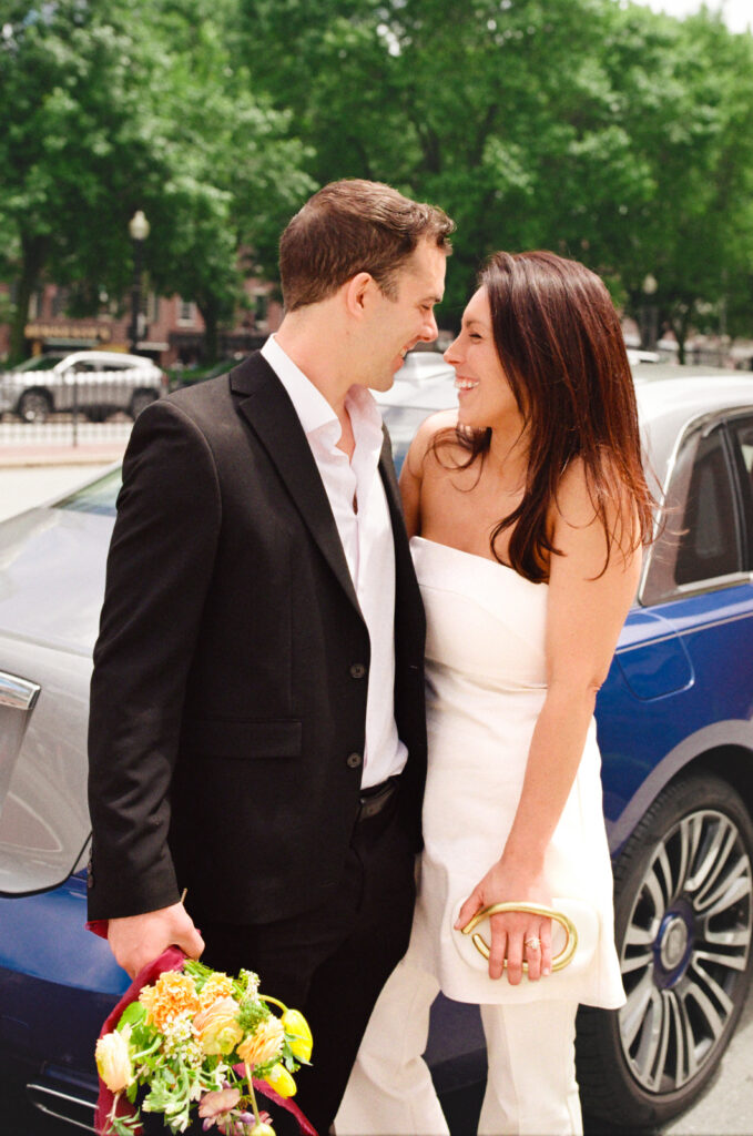newly married couple smiling at each other and giggling 