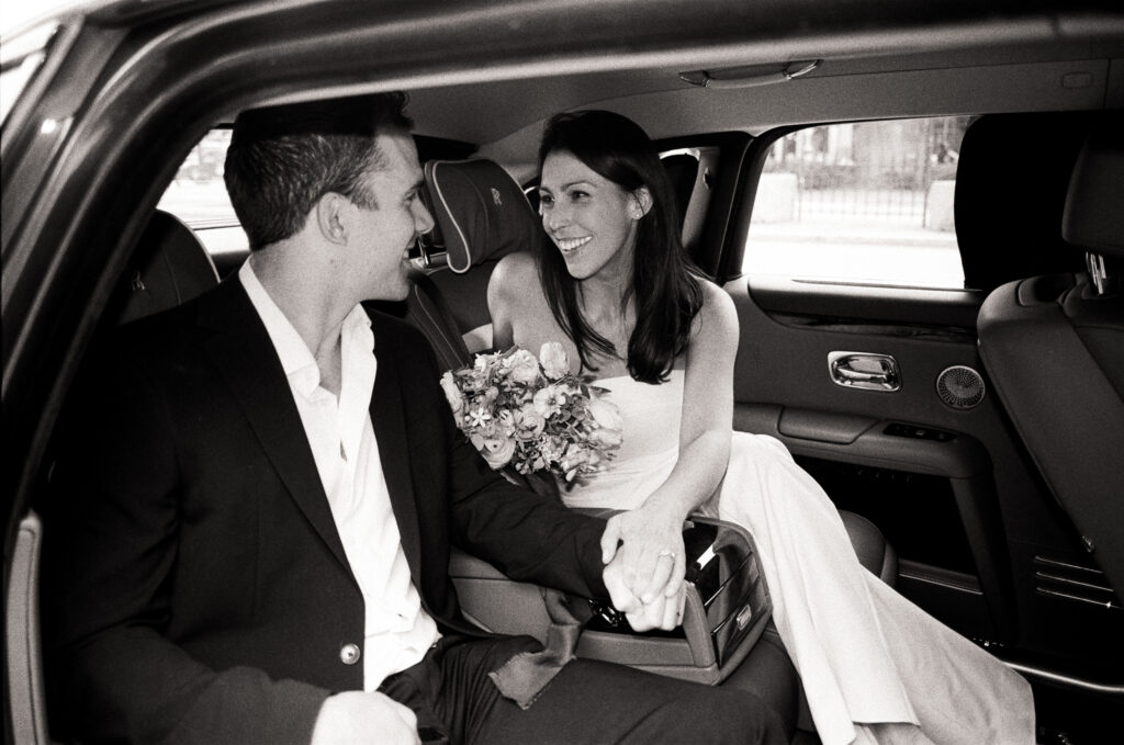 bride and groom smiling at each other in a luxury car leaving the courthouse after their elopement 