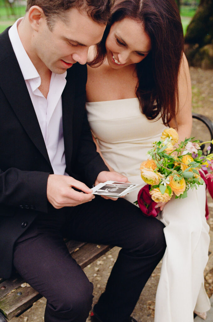 bride and groom looking at polaroid photos from their Boston City Hall elopement 