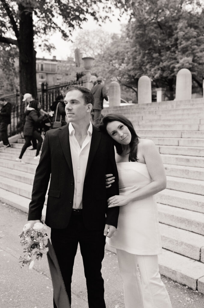 bride and groom posing in front of steps in a black and white photo 