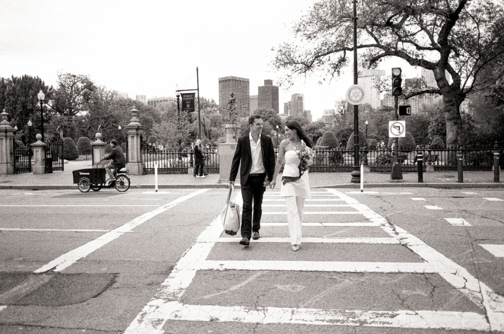 bride and groom crossing the street at a crosswalk after their Boston City Hall Elopement 
