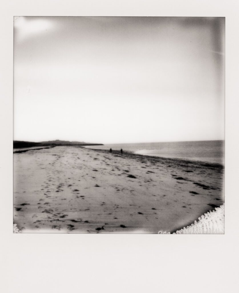polaroid photo of couple walking down the beach during Cape Cod engagament photos