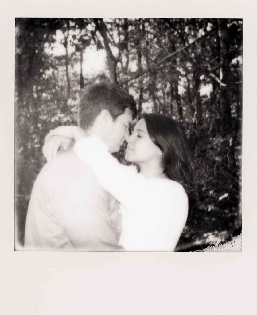 polaroid photo of couple hugging and leaning in for a kiss during film engagement photos in Cape Cod