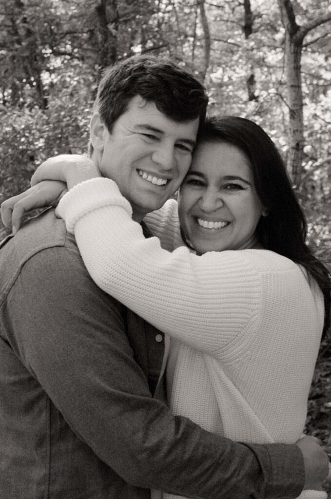 black and white photo of a couple hugging and smiling during engagement photos in Cape Cod