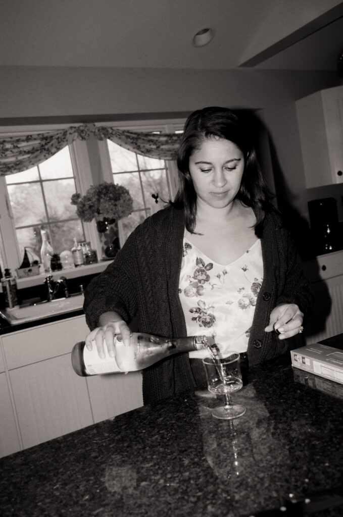 woman pouring a glass of wine in black and white photo
