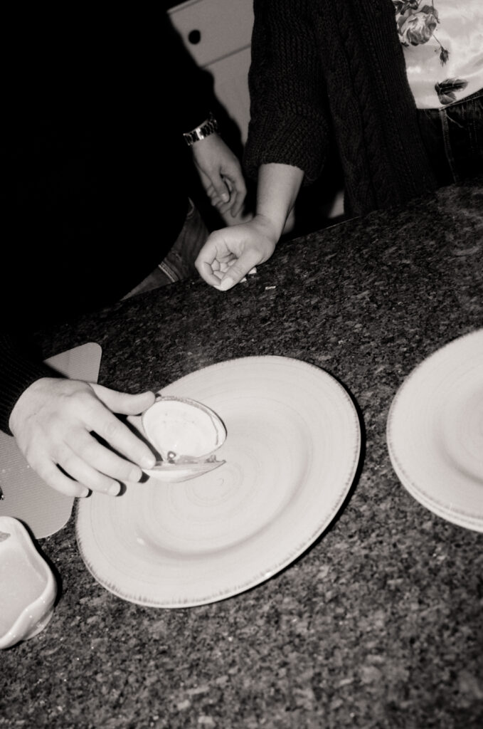 hands placing clam on a white plate