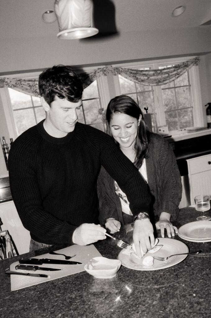 man and woman cooking clams and tasting them in black and white photo