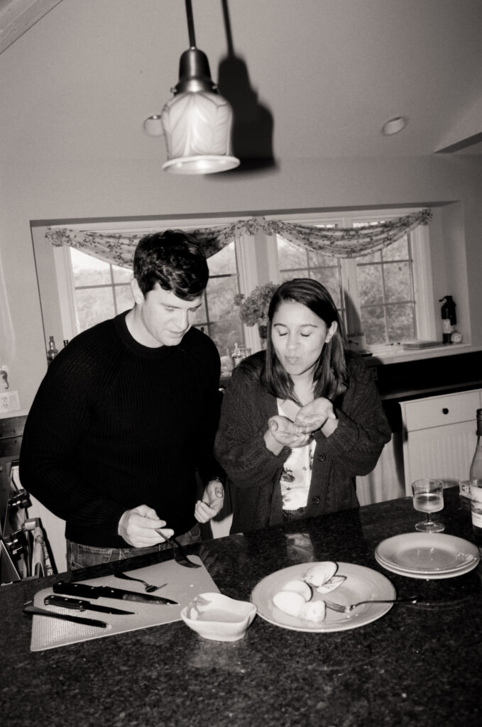 man and woman cooking clams and tasting them in black and white photo