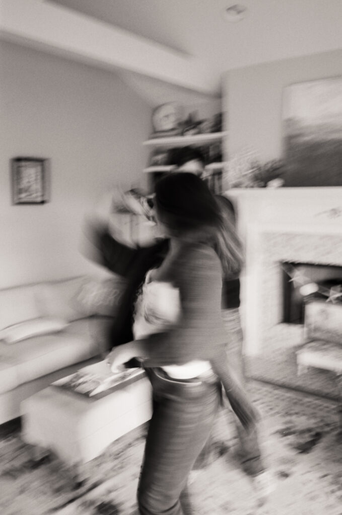 blurry black and white photo of couple dancing in living room during film engagement photos in Cape Cod