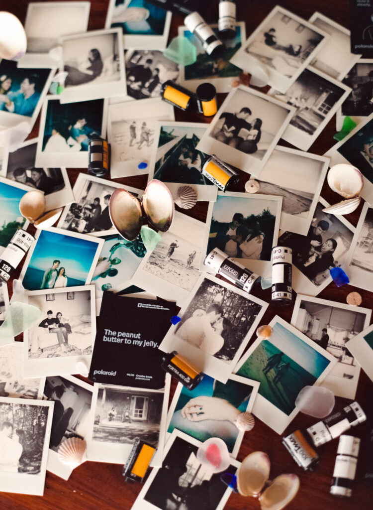 polaroid photos, shells, and rolls of film layered out on a tbale